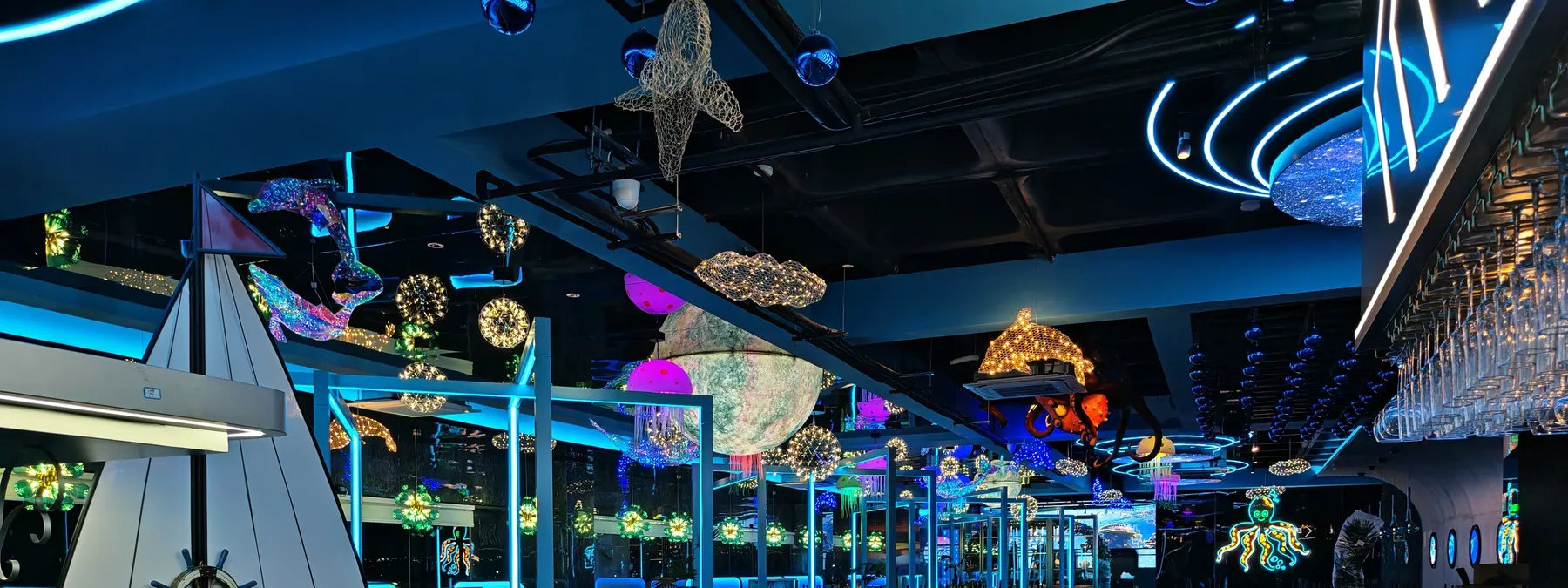 Velero decorativo y figuras marinas de luz en el techo del comedor